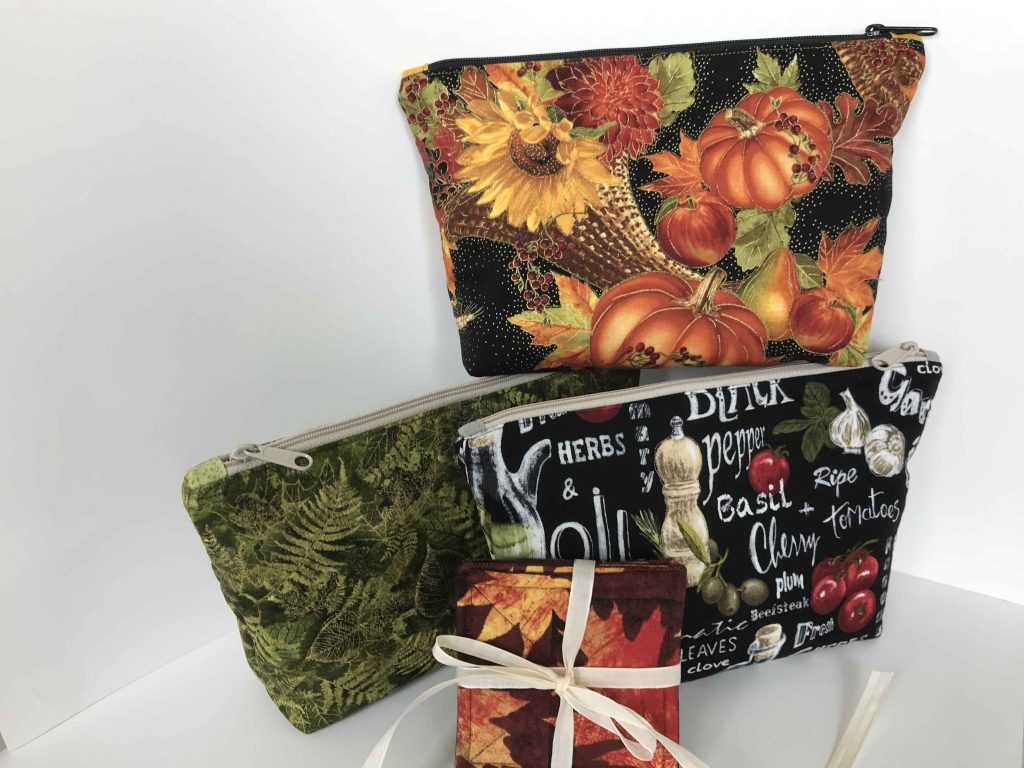 3 large quilted zipper pouches are displayed in fall fabrics plus a fall fabric coaster set